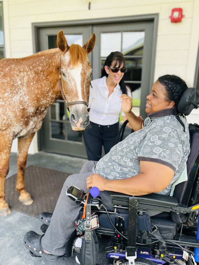 horse therapy session on location woman in wheelchair smiles at horse